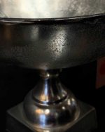نمای بسیار نزدیک از بدنه‌ی ظرف پایه دار آلومینیومی وارداتی از روبه‌رو بدون نور